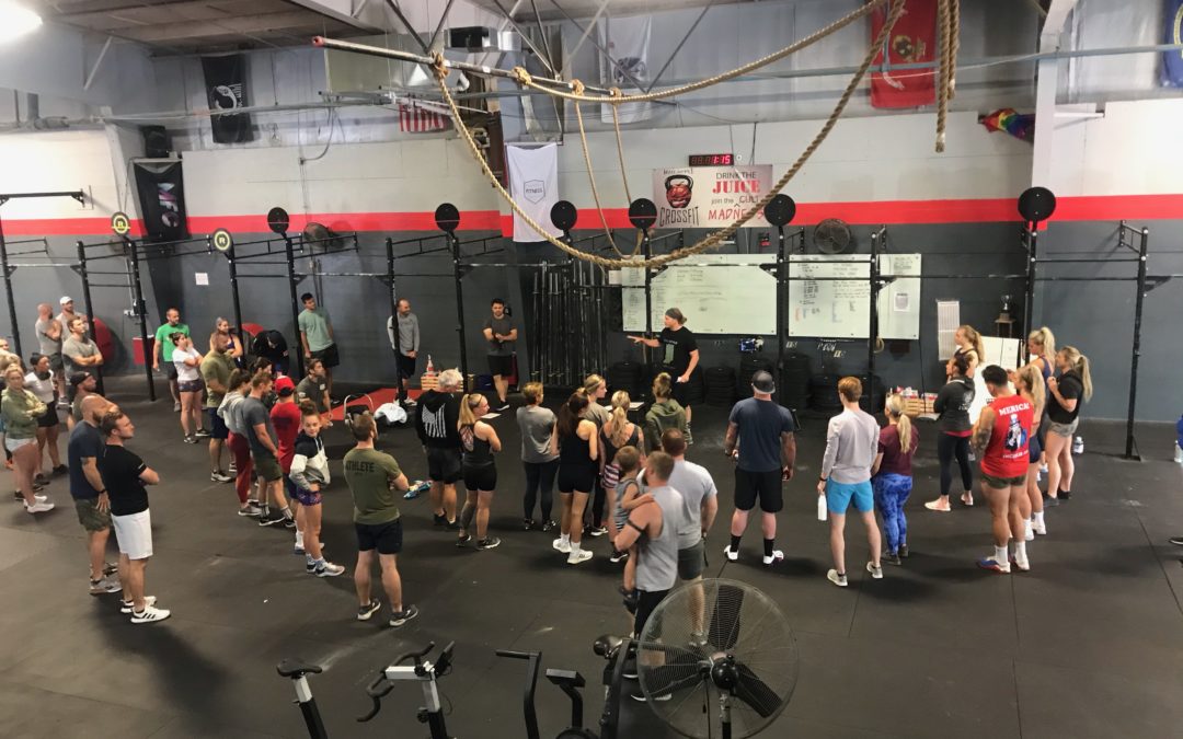 Image coach instructing people during workout routine at Mad Apple